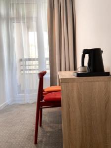 乌斯特龙Ośrodek Tulipan的椅子,旁边是一张桌子,配有咖啡壶
