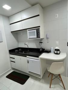 若昂佩索阿Melhores Flats - Tranquilo, pertinho do mar的白色的厨房配有水槽和微波炉