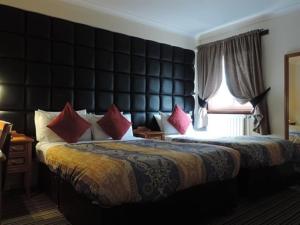 格拉斯哥列王公园酒店的酒店客房配有一张带红色枕头的大床