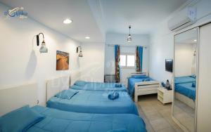 达哈布Dolphina hotel & Restaurant的一间卧室配有两张蓝色的床和镜子