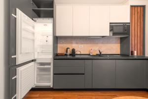 皮特什蒂Pitesti Residence的厨房配有白色橱柜和开放式冰箱。