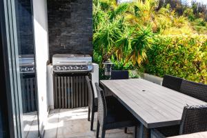 BolansTamarind Hills Resort & Villas的露台上的烧烤架和木桌