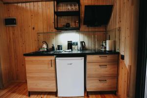 UpesgrīvaBrīvdienu māja Jaunzvīņas的厨房配有白色冰箱和木制橱柜。