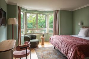 巴黎Royal Garden Champs-Élysées的卧室配有床、椅子和窗户。