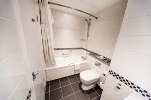 利兹皇冠假日利兹酒店的浴室配有卫生间、浴缸和水槽。