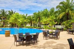 乔木提恩海滩View Talay Villas - Luxury 1BR pool villa nr beach - 171的游泳池旁带桌椅的天井