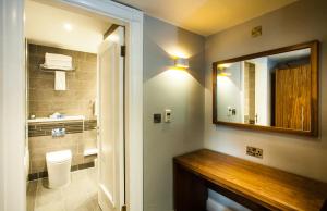 利兹皇冠假日利兹酒店的浴室设有镜子、盥洗盆和卫生间