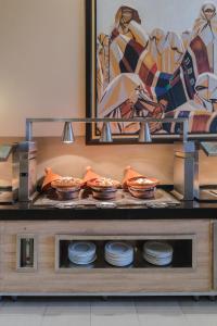 马拉喀什Kenzi Menara Palace & Resort的架子上的自助餐,包括碗和盘子