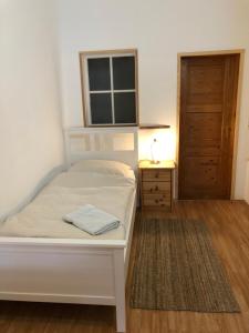 GömnitzDas Abendrote Haus的卧室配有白色的床,铺有木地板