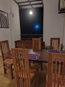 韦利格默Rusara Guest Home的一间带桌子和木椅的用餐室