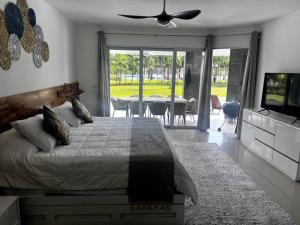 普拉亚卡门MAREAZUL Beachfront Apartment 2BR Private Pool Casa Áncora的一间卧室配有一张床、一台电视和一张桌子