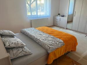 蒂米什瓦拉Amma House Timisoara的一间卧室配有一张带橙色毯子的床