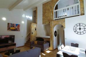 乐巴凯尔斯Villa H2o - Jacuzzi & Piscine chauffée的客厅配有沙发和墙上的时钟