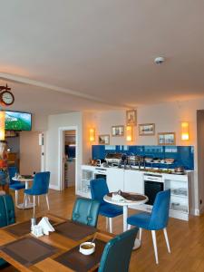 巴统Orbi floor40的一间带蓝色椅子的客厅和一间厨房
