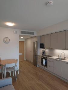 图尔库Uusi korkea tasoinen kaksio, ilmastointi的厨房配有白色橱柜、桌子和用餐室。
