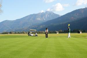 索内纳尔佩·纳斯费尔德纳斯费尔德酒店的两人站在高尔夫球场上,带高尔夫球车