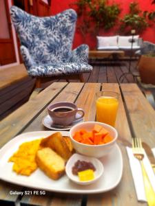 莱瓦镇Hotel Caney Villa de Leyva by MH的木桌上的早餐盘