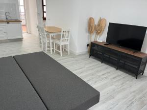 米哈斯Ataraxia Casa Vacacional的客厅配有平面电视和桌子。