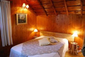 维拉尔-德朗Les Castors的木制客房内的一间卧室,配有一张床