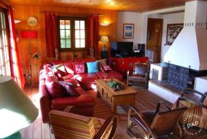 维拉尔-德朗Les Castors的客厅配有红色的沙发和桌子
