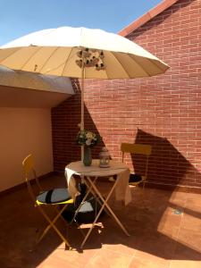 帕伦西亚INSIDEHOME Apartments - La Casita de Irene的白色遮阳伞下的桌椅