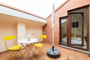 帕伦西亚INSIDEHOME Apartments - La Casita de Irene的庭院设有黄色的椅子、桌子和窗户。
