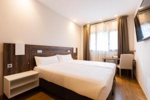 帕伦西亚INSIDEHOME Ciudad de Palencia的卧室配有一张白色大床和一张书桌