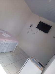 São Gonçalo do AmarantePousada da Rotatória的白色客房,地板上设有一张床和一个箱子