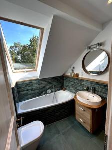 柏林Loft in Historischer Schmiede的带浴缸、水槽和镜子的浴室