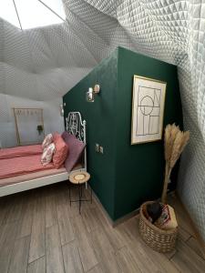 霍雷祖The Frog Glamping的一间卧室设有一张床和绿色的墙壁