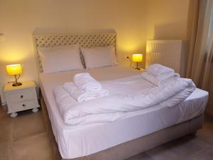 波尔塔里亚Marousos Central Guesthouse的一间卧室配有带白色床单和枕头的床。