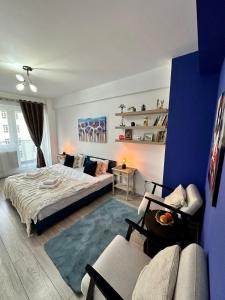雅西Q Apartament Palas Mall的一间卧室配有床、沙发和蓝色的墙壁