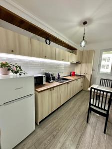 雅西Q Apartament Palas Mall的厨房配有木制橱柜和白色冰箱。