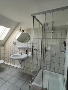 埃森法布里兹酒店的一间带玻璃淋浴和水槽的浴室