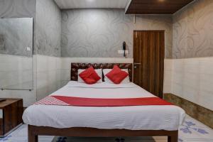 孟买OYO Flagship Hotel Sapna Residency的一间卧室配有一张带红色枕头的大床