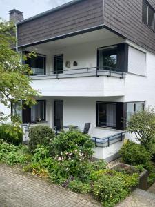 施马伦贝格Ferienwohnung Gierse的白色的房子,设有黑窗和庭院