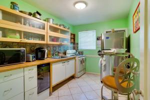 西棕榈滩West Palm Beach Home with Fenced-In Yard and Deck!的厨房设有绿色的墙壁和白色的橱柜。