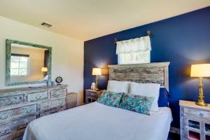 西棕榈滩West Palm Beach Home with Fenced-In Yard and Deck!的一间蓝色卧室,配有一张床和镜子