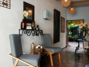 梅里达Hotel Boutique Casa Flor de Mayo的客厅配有两把椅子和一张桌子
