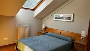 Vivienda Falda del Monsacro的一间卧室设有蓝色的床和窗户。