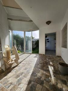拉马萨Duplex bien equipe securise avec jardin et veranda的一间空房间,设有石地板和大窗户