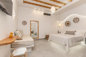 斯希努萨岛Porto Dema Luxury Suites的白色卧室配有床和镜子