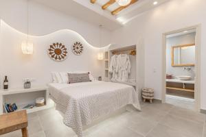斯希努萨岛Porto Dema Luxury Suites的一间白色卧室,配有床和一间浴室