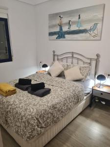 坎波阿莫Apartament Playa Marina II/Cabo Roig的卧室配有一张大床,墙上挂有两张照片