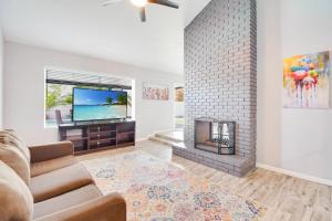 凤凰城Greenway Villa, Newly remodeled, Pool, Putting green and Patio的客厅设有壁炉和电视。