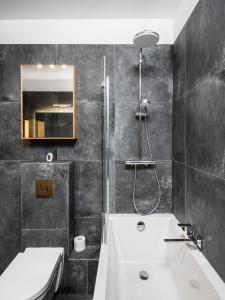 华沙Apartments 24h的浴室配有白色浴缸和水槽