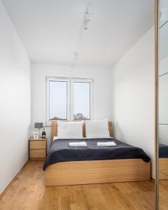 华沙Apartments 24h的一间卧室设有一张床和两个窗户。