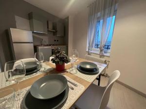 罗韦雷托La Zinevra的厨房配有带盘子和酒杯的桌子