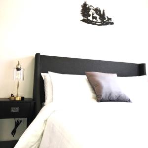 坎莫尔Mountain Retreat: Brand New 2BR Condo的一间卧室配有一张带黑色床头板和床头柜的床。