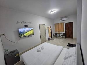 勿洞Ban Chahomm Guesthouse的一间医院房间,里面设有一张床和墙上的电视